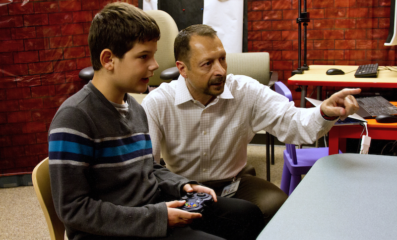 Tony Simon shows a student his video game, Fastbrain