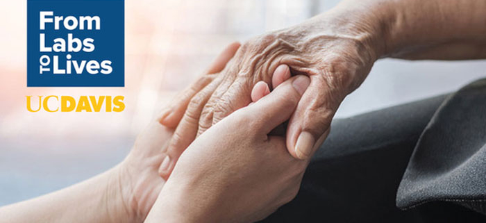 A younger hand gently holds an older hand, conveying care and support. Beside them, a blue square displays the text “From Labs to Lives” above the UC Davis logo.