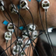 Close-up of a person’s neck and lower face with multiple small circular sensors attached to the skin, each connected by thin wires.