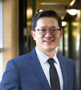 portrait of aijun wang with hallway in the background