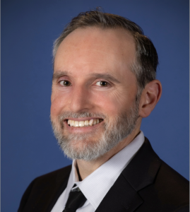 portrait of chris lucchesi with blue backgroun