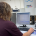 person sitting at a computer with a piece of equipment in front of them
