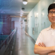 Isaac Kim dressed in white shirt, stands in building lobby with visual overlay of abstract artifical intelligence treatment on side