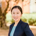 Head and shoulders of smiling woman in dark blue suit