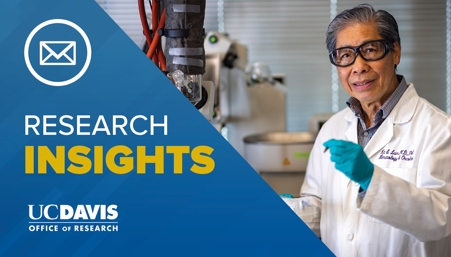 Scientist in lab wearing white lab coat, black glasses and blue gloves