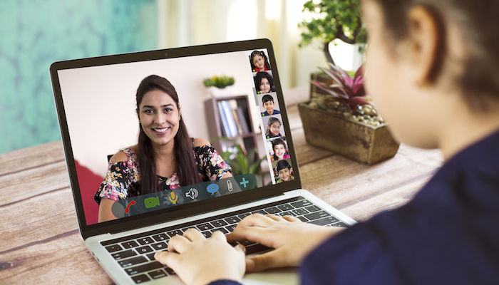 Girl participating in online education training class with teacher and other students using laptop at home. (iStock photo)