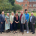 a group of people stand in front of lawn in front on red brick building